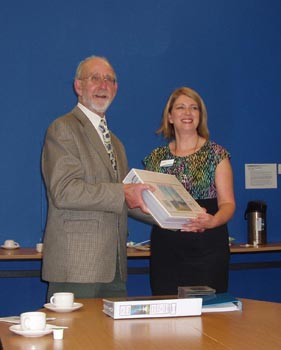 Andrew Grant hands the portfolio to Jill Marple, Team Leader at Leith Library