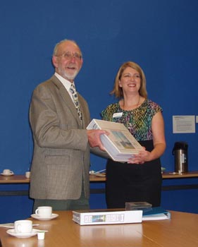 Andrew Grant hands the portfolio to Jill Marple, Team Leader at Leith Library