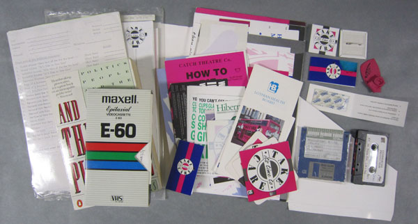 A diverse group of objects found in the HIV/AIDS collections consisting of VHS and audio cassettes, 3.5 inch floppy discs, stickers, balloons, badges, condoms and paper materials
